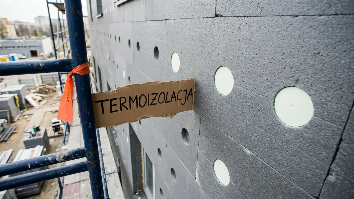 Fasada ze styropianem grafitowym i zamontowanymi białymi zaślepkami zapobiegającymi mostkom cieplnym.